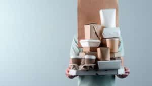image showing a restaurant worker holding boxes of food awaiting pickup - header image for which delivery service is best for restaurants post